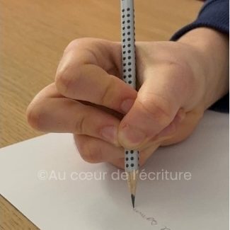 un enfant a mal à la main en écrivant